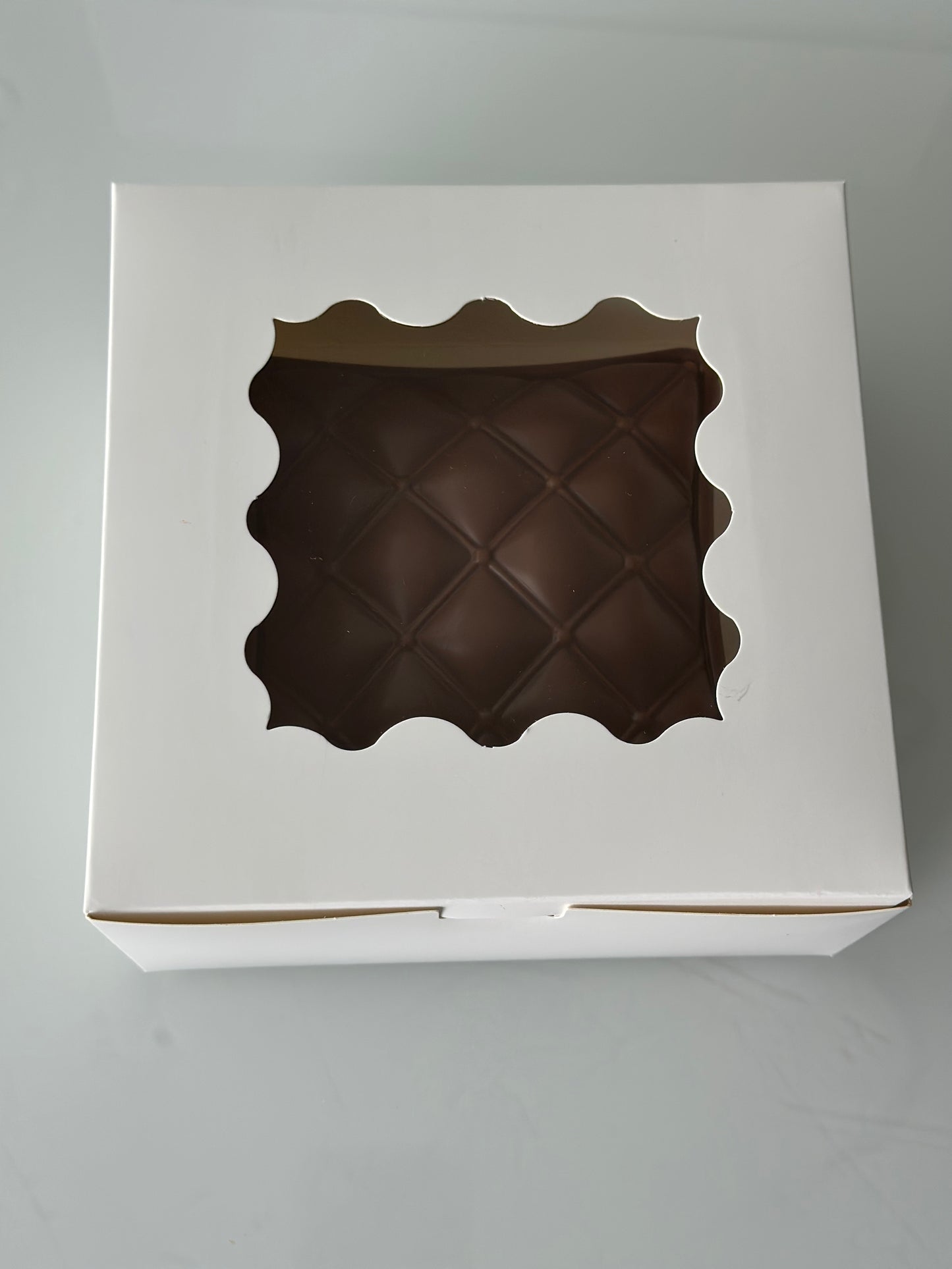 A white window box with chocolate inside