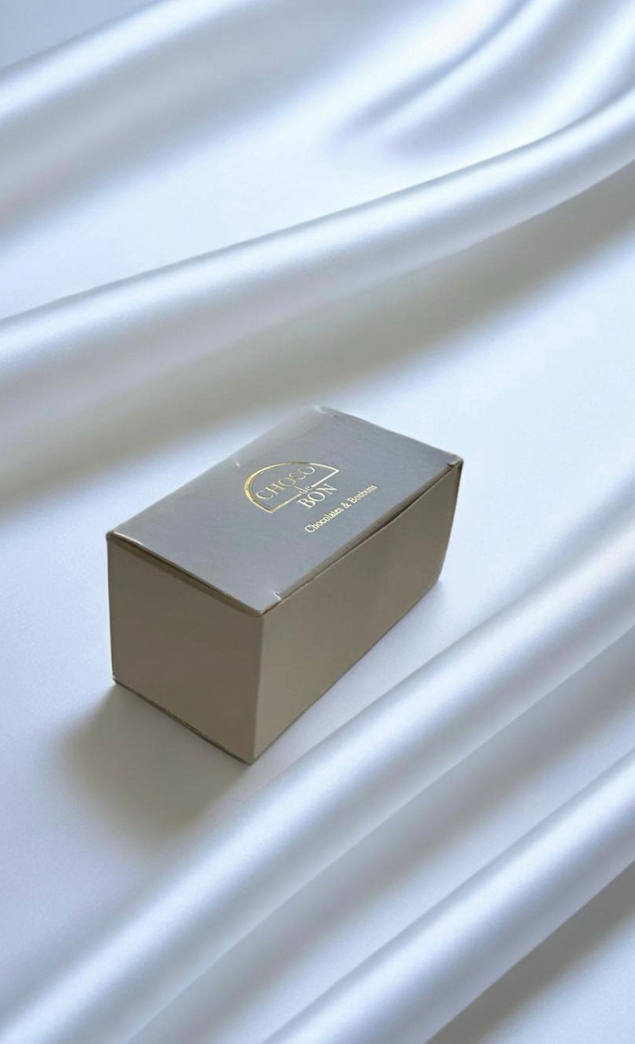 White chocolate box with gold logo on top